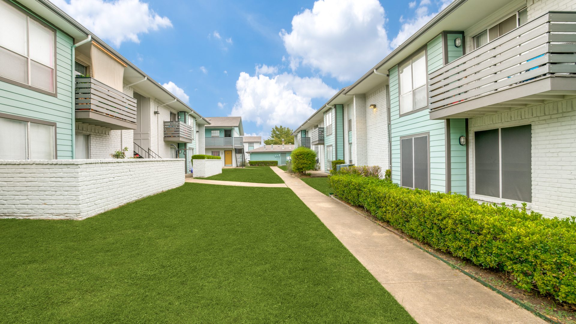 apartment complex with lawn and grass in front at The Las Ventanas